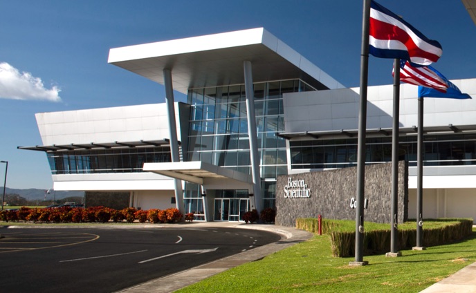 Boston Scientific manufacturing plant in Costa Rica with Costa Rican and American flags flying in front.
