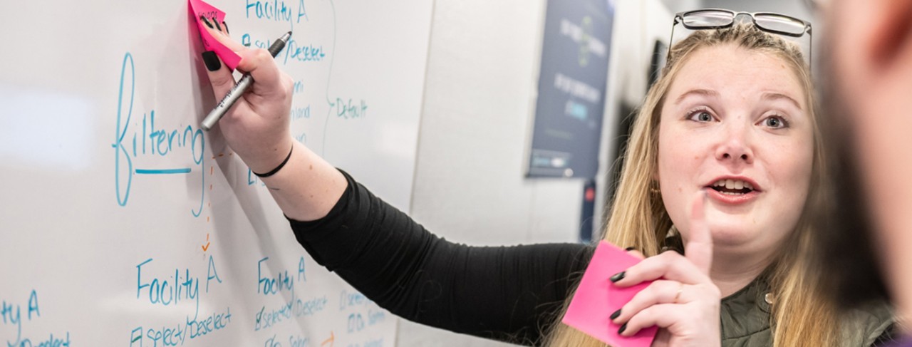 A Boston Scientific employee using a white-board to collaborate with colleagues.
