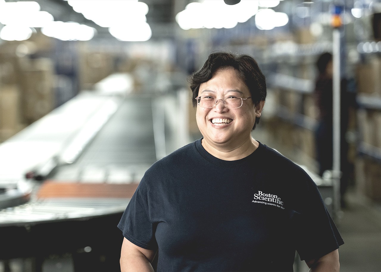 Employee wearing a Boston Scientific shirt smiles into the camera.