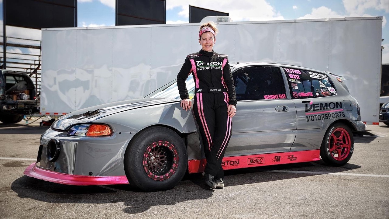 Driver Nichole Elff photo with her sport car in race suit