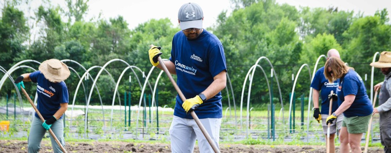 Group of Boston Scientific volunteers cleaning garden in their community tshirt.