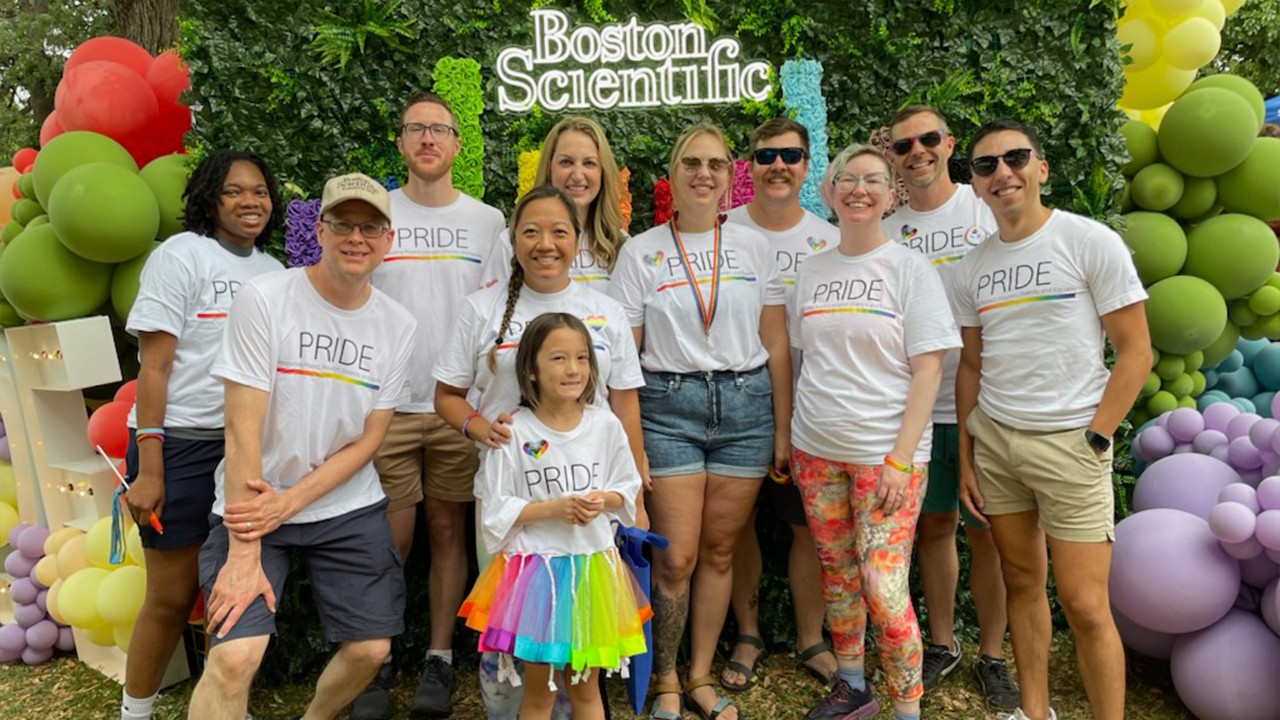 group of smiling people wearing boston scientific pride community Tshirt